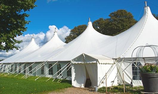 a row of blue portable restrooms waiting to be used at a special event in Dedham, MA